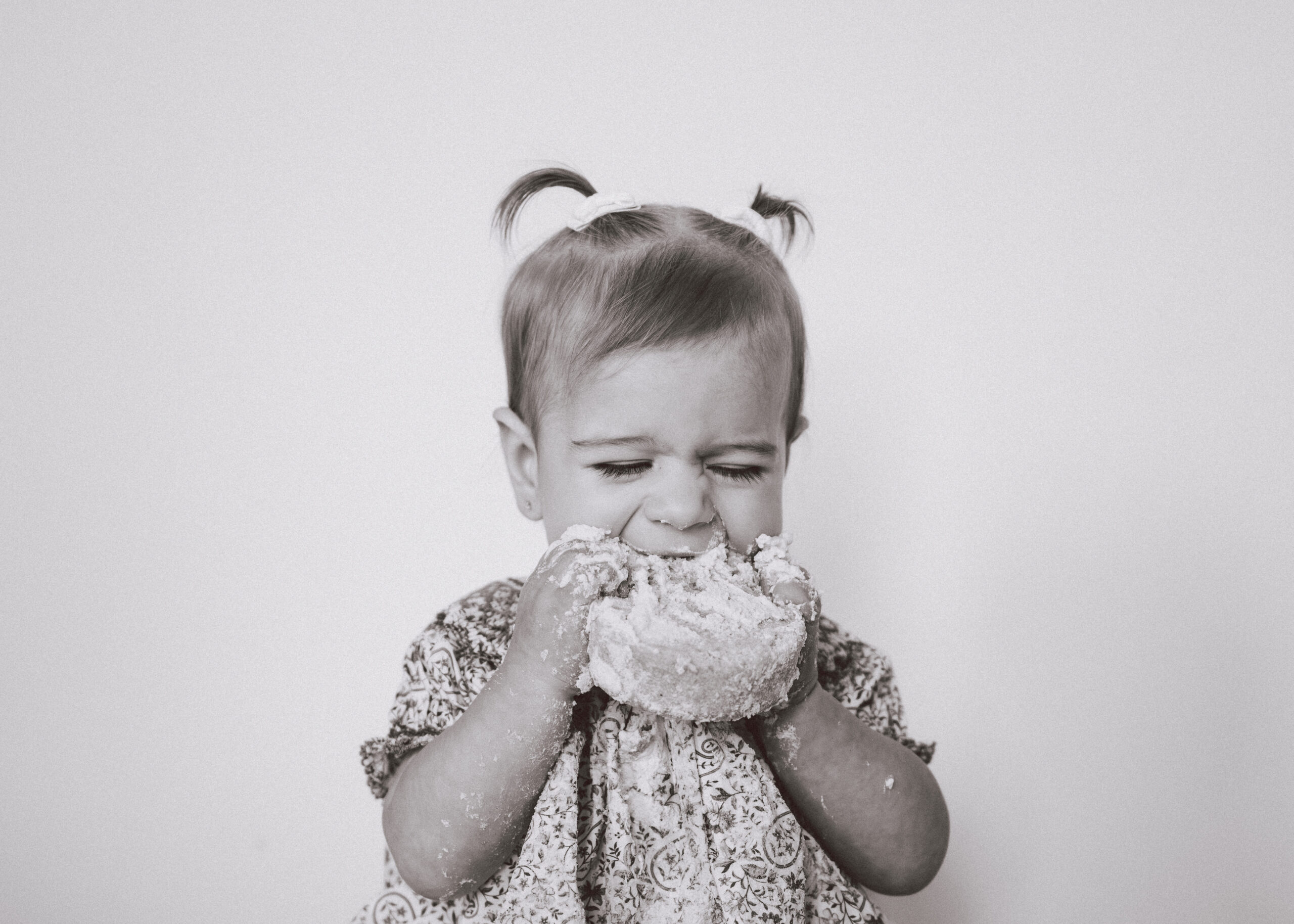One year old girl smashing and eating her birthday cake | Asheville cake smash photographer